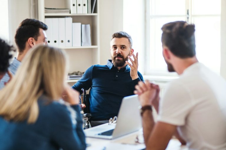 Mediación Familiar Hombres y mujeres discutiendo en una reunión en una oficina iluminada.